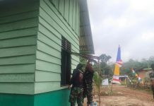 Warga Bersama Satgas TMMD ke-117 Kodim 0416/Bute Cat Kusen Rumah Milik Edi Candra